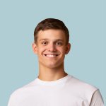 Smiling young man in white t-shirt, promoting real estate agent services in Australia.