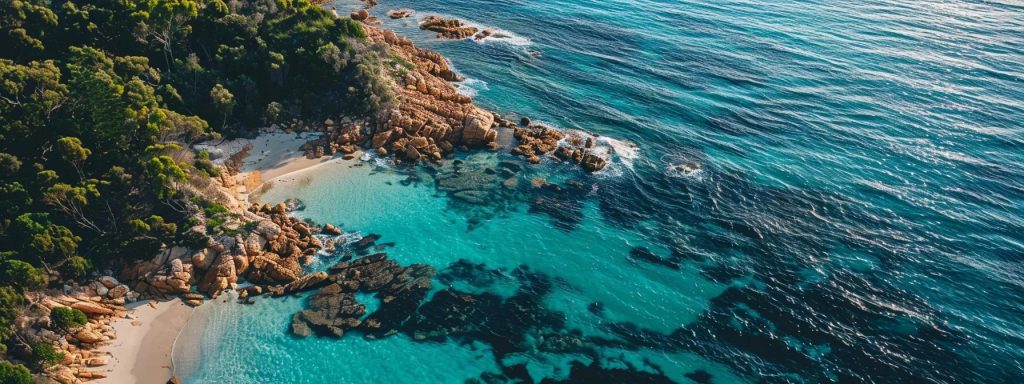 Aerial view of a serene beach with turquoise waters, rocky coastline, and lush greenery, reflecting the natural beauty of Australia's property investment locations.