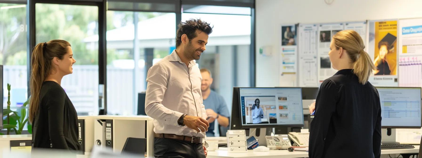 Office environment with professionals discussing property buying, featuring computers and documents, relevant to Queensland property costs and insurance.