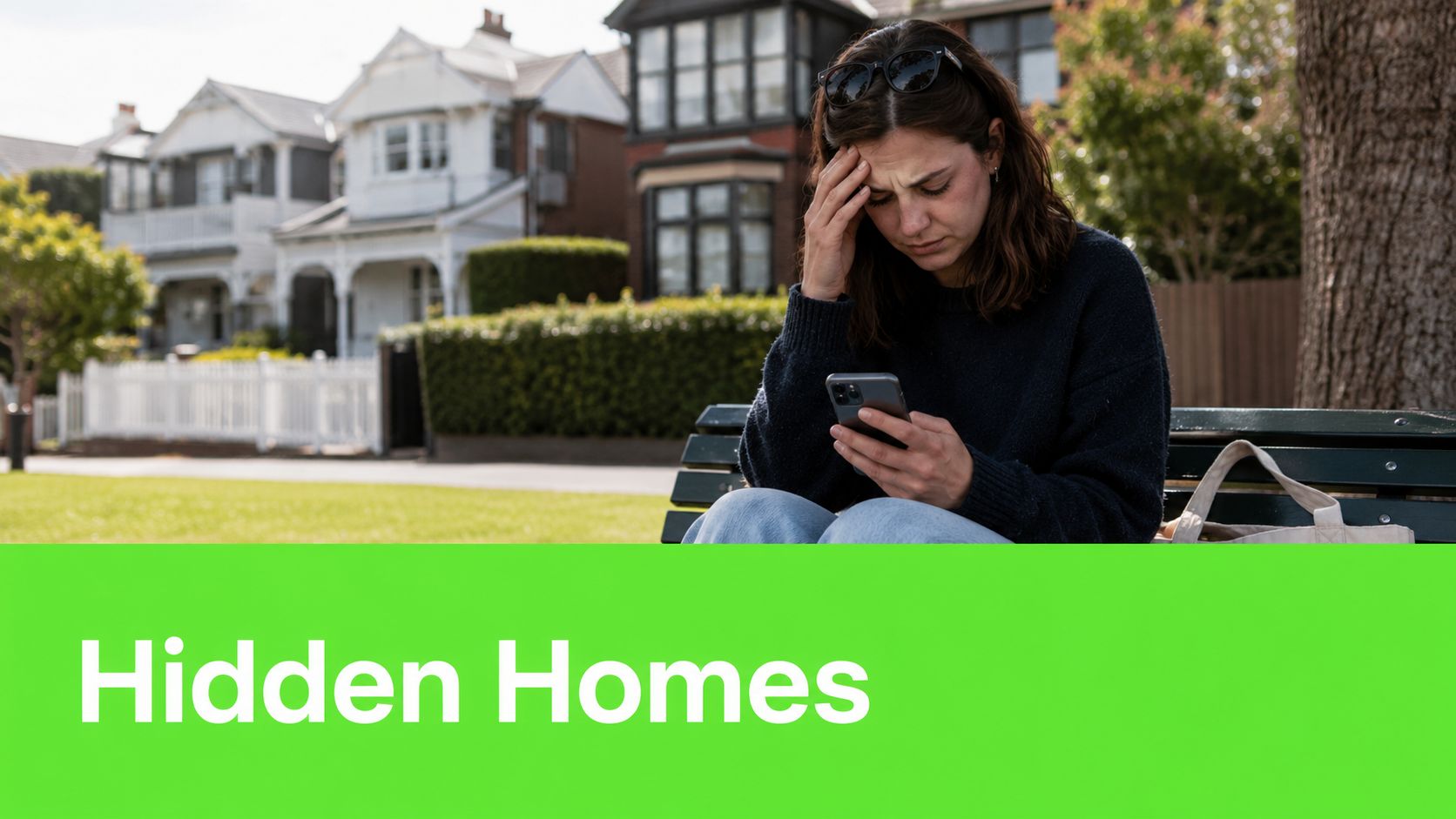 A woman sits on a park bench looking stressed while holding her smartphone in front of houses.